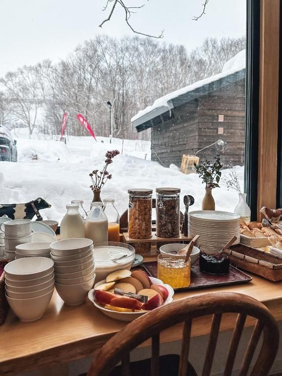 Rustic breakfast spread overlooking a snowy woodland countryside scene